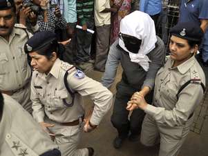 A turista é escoltada para realizar exames médicos na Índia Foto: AP