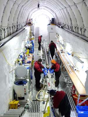 Pesquisadores trabalham em amostras de gelo recolhidas na ilha Roosevelt, na Antártida. A equipe cavou uma espécie de vala na neve a partir da qual perfurou o gelo Foto: AP