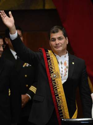Correa acena durante cerimônia de posse para o seu segundo mandato, em Quito Foto: AFP