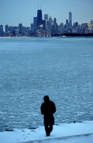 Homem caminha às margens do lago Michigan, que congelou devido às baixas temperaturas Foto: / AP