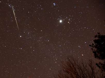 Um meteoro cruza o céu durante a chuva de meteoros anual Geminídeas sobre Springville, Alabama Foto: AP