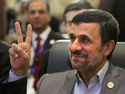 O presidente do Irã faz sinal da vitória ao comparecer à conferência islâmica no Cairo Foto: AP