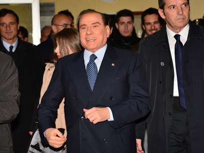 Sorridente, Berlusconi deixa seção eleitoral após votar em Milão no último domingo Foto: AFP