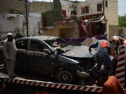 Agentes dos serviços de segurança inspecionam veículo atingido pela explosão em Karachi Foto: AFP