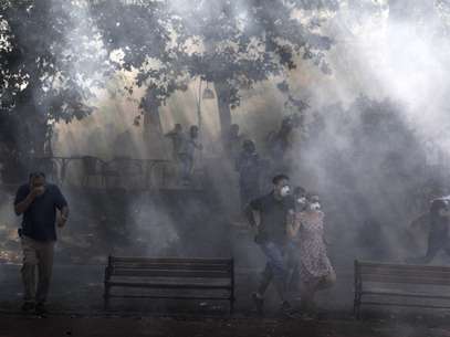 Manifestantes fogem do gás lacrimogênio lançado pela polícia em Istambul Foto: AFP