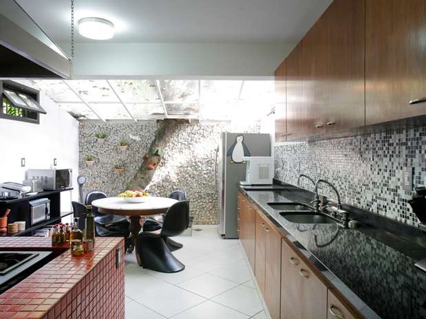 Para aumentar a cozinha de uma casa no Rio de Janeiro sem derrubar o jasmim manga que ficava no fundo do terreno os arquitetos Fernanda Bessone e Raul Moras incorporaram a árvore ao cômodo Foto:  / Leo Costa