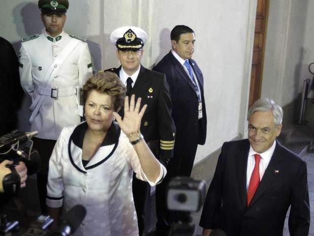 Dilma Rousseff acena para jornalistas ao lado do presidente do Chile Sebastián Piñera após chegar ao palácio La Moneda Foto: Andres Stapff / Reuters