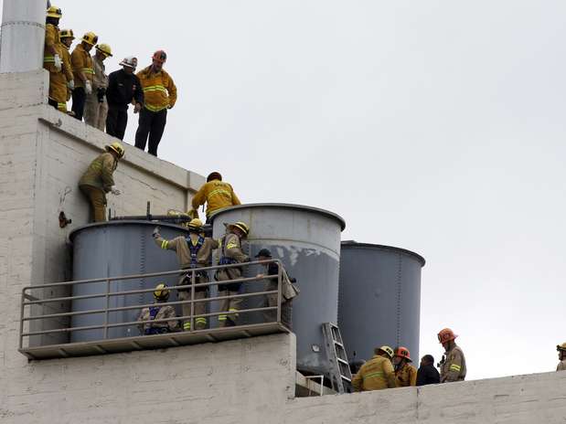 Bombeiros trabalham para remover o corpo encontrado dentro de uma das caixas d'água do hotel na terça-feira Foto: Reuters