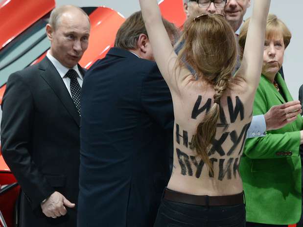 Putin observa jovem ativista protestar durante sua visita à Feira de Hannover Foto: AFP
