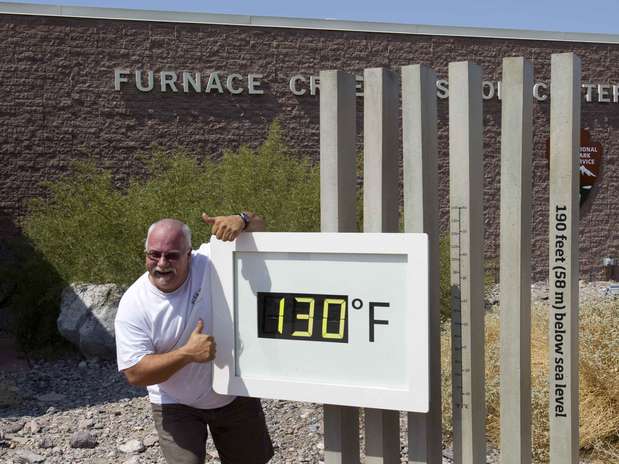 Craig Blanchard posa ao lado de termômetro marcando 130°F (54,4°C) no Parque Nacional de Death Valley no sábado. A medida não era oficial Foto: Reuters