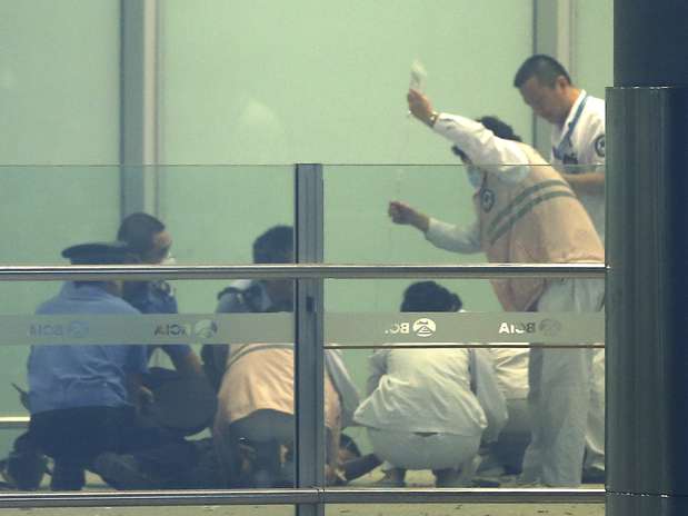 Médico e policiais atendem o que se acredita ser uma pessoa ferida na explosão Foto: AP