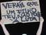13 de junho - Mascarado, manifestante protesta e levanta cartaz com trecho do hino nacional