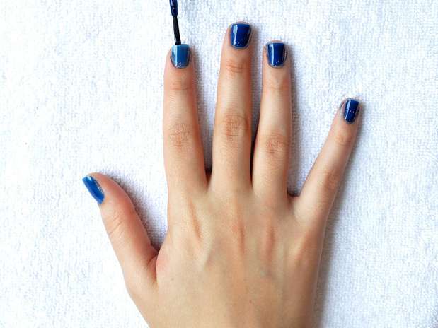 2. Passe duas camadas do esmalte azul biônico, da Colorama, e limpe as laterais com o algodão embebido em removedor enrolado no palito. Se você não tiver muita habilidade para retirar os excessos pode utilizar uma caneta removedora de esmalte. Depois, passe uma terceira demão fazendo uma esmaltação europeia, ou seja, sem encostar o esmalte na cutícula Foto: Bruno Santos/Terra