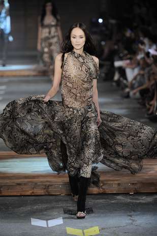 O estilista italiano Roberto Cavalli tem como marca registrada estampas de animais, como neste vestido fluido que lembra a pele de cobra, do último desfile de verão, em setembro de 2011, em Milão Foto: Getty Images