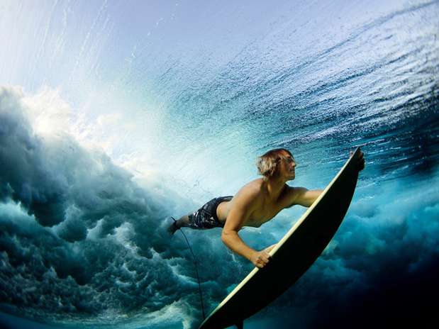 A fotógrafa Lucia Griggi criou esta cena incrível em um banco de corais próximo à ilha de Fiji, chamado de Cloud Break. Ela mostra um surfista mergulhando com sua prancha para passar a forte ondulação do local Foto: Lucia Griggi/National Geographic Traveler Photo Contest