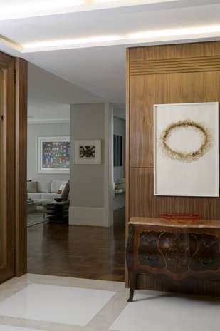 Como esse hall tem muitas portas, Marcelo Rosset quis sumir com elas com um painel de madeira igual à madeira utilizada nelas Foto: Marco Antônio