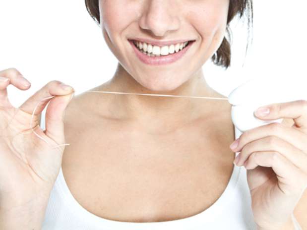 Há quem prefira passar o fio dental antes de escovar os dentes, outros passam depois da escovação, e há, ainda, aqueles que esquecem completamente dessa etapa da higiene bucal. O perigo é deixar acumular restos de alimentos entre os dentes, naqueles espaços tão apertados que só o fio dental consegue chegar. Foto: Shutterstock Há quem prefira passar o fio dental antes de escovar os dentes, outros passam depois da escovação, e há, ainda, aqueles que esquecem completamente dessa etapa da higiene bucal. O perigo é deixar acumular restos de alimentos entre os dentes, naqueles espaços tão apertados que só o fio dental consegue chegar. Foto: Shutterstock