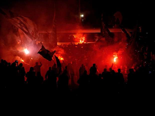 Torcida começou a fazer festa cedo no Aeroporto de Guarulhos, mas a chegada do ônibus com jogadores do Corinthians empolgou ainda mais os 15 mil presentes no local. Os atletas apareceram no estacionamento por volta das 23h (de Brasília) e saíram do ônibus para ver os corintianos Foto: Fernando Borges / Terra