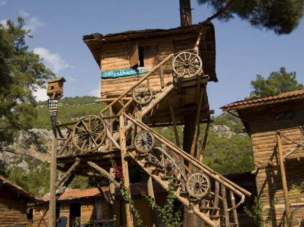Kadirs Tree House Hotel, Turquia: entre os pinheiros e louros que coroam o vale Olympus, no sul da Turquia, se encontra uma versão para adultos de uma clássico fantasia infantil: uma casa em uma árvore. O Kadirs Tree House Hotel é um grupo de camarotes com cabines grandes empoleiradas nos troncos. Alguns têm um toque rústico incrivelmente realista. O único inconveniente é a falta de privacidade, já que tem capacidade para acomodar até 300 hóspedes. O hotel só aceita clientes com reservas e estadia mínima é de três noites. Para se hospedar, pagam cerca de 200 reais por noite Foto: Divulgação
