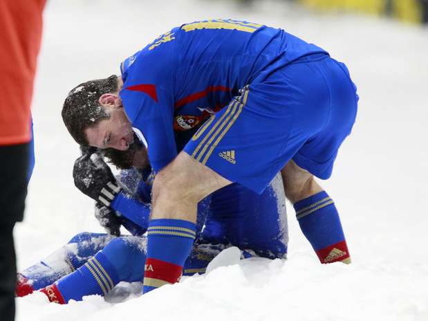 Mamayev (sentado) e Dzagoev comemoram no meio da neve, fora do campo, o segundo gol do CSKA Foto: Getty Images Mamayev (sentado) e Dzagoev comemoram no meio da neve, fora do campo, o segundo gol do CSKA Foto: Getty Images
