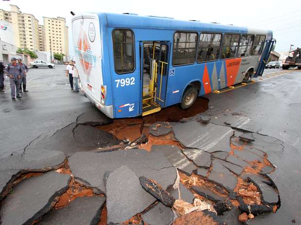 A chuva fez o asfalto ceder e deixou um ônibus preso em Uberaba Foto: Ladolfo/Estadão Conteúdo / Agência Estado