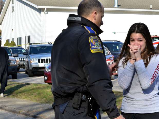 Mulher chora enquanto espera por informações da irmã, uma professora do colégio Foto: AP