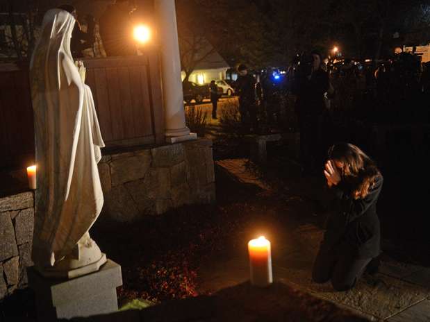 Pessoas rezaram na Igreja de Santa Rosa após o tiroteio na escola em Connecticut Foto: AFP