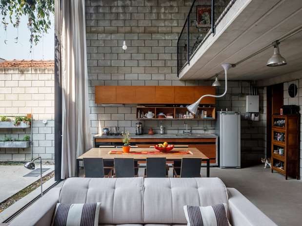 Para acabar com a divisão tradicional entre a área social e o quintal da casa, o arquiteto Danilo Terra optou por fazer uma porta de vidro de pé direito duplo que se abre quase completamente Foto: Pedro Kok