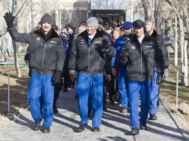 Membros da missão acenam ao deixar hotel rumo ao Cosmódromo de Baikonur Foto: Reuters
