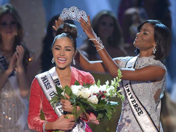 Olivia Culpo recebe coroa de brilhantes da angolana Leila Lopes, vencedora do concurso de 2011 Foto: AFP