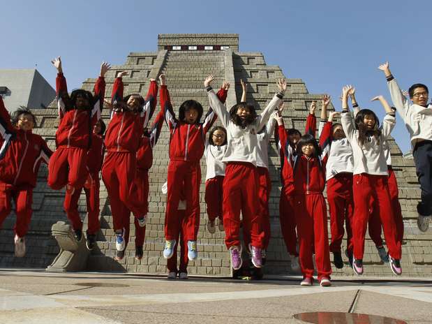 Taiwan - Estudantes comemoraram que o mundo não acabou na hora prevista em frente à réplica de pirâmide maia em Taichung Foto: AP