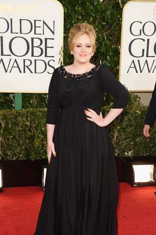 Para prestigiar o Globo de Ouro, Adele não saiu de sua zona de conforto e escolheu um Burberry imperial preto de mangas 3/4. O charme do modelo ficou por conta da gola trabalhada em brilho Foto: Getty Images