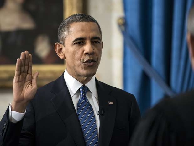 O presidente Barack Obama levanta o braço direito e faz o juramento diante do juiz John Roberts, presidente da Suprema Corte Foto: AP