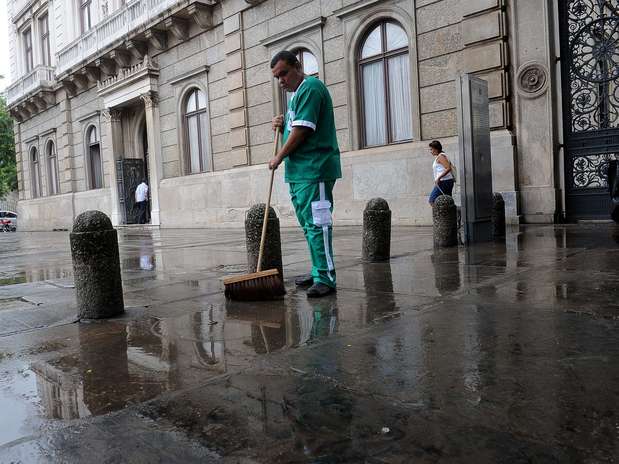 Funcionário limpa a calçada do Palácio do Catete após a chuva Foto: Daniel Ramalho / Terra