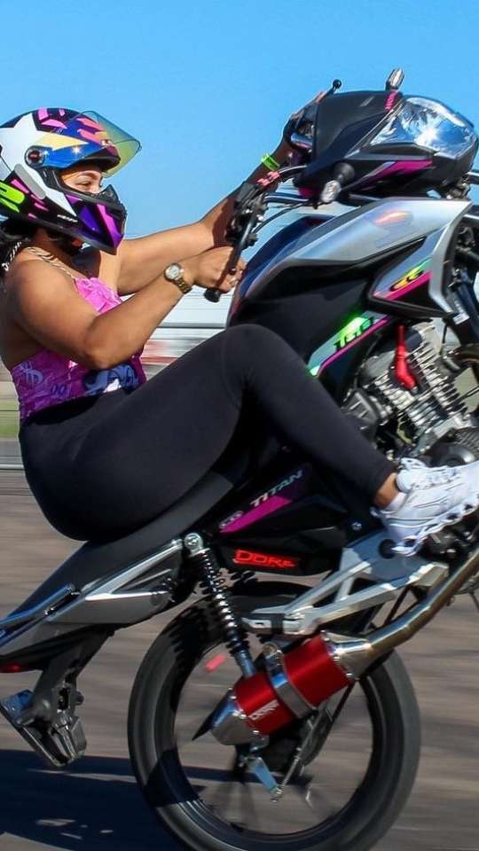 mulher dando um grau na moto 160